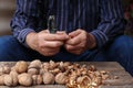 Man cracking walnuts at wooden table Royalty Free Stock Photo