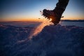 Man in crampon spike boots climbs to the top of a snowy mountain in winter.