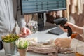 Man with credit card buying gift in a female clothing store. Woman cashier, seller scanning using barcode scanner at the checkout. Royalty Free Stock Photo