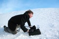 Man creeps on snow with brief-case