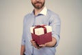 Man cropped view gift present box pack tied with red ribbon selective focus, gifting