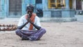 Man with crossed legs and hands meditating in front of an hinduist temple