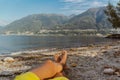 Man with crossed legs relaxing on the Lakeshore in Locarno, lake maggiore Royalty Free Stock Photo