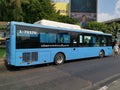 A man crosses an alley in front of a bus