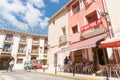 Man crosses street while women enjoy morning drink in shade outside