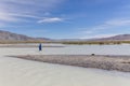 Man crosses a white mountain river on foot. Altai, Mongolia