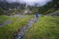Man crossing river stream in alpine mountain valley of Sulzenau Alm, Stubai Alps, Austria Royalty Free Stock Photo