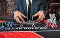 Man croupier holding playing cards before start game poker at casino. Texas holdem