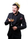 Man in crown, black suit with wine glass in hand .