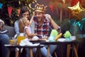 Man with crown at head have fun at birthday party with family Royalty Free Stock Photo