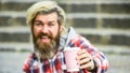Man with a cup of coffee outdoors. selective focus. Handsome calm bearded man outdoors with a cup. Man drinking hot