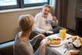 Man with cup of tea or coffee and woman having breakfast looking at each other Royalty Free Stock Photo