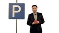 Man with cup of tea near parking sign on white background isolated