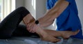 Man is curing leg of woman in clinic of osteopathy, rehab center for sportsmen