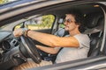 Man with curly hair driving a car and smoking a cigarette