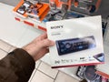 Man customer hand holding package of new auto radio manufactured by SONY modern Royalty Free Stock Photo