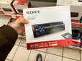 Man customer hand holding package of new auto radio manufactured by SONY modern