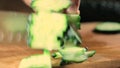 Man cut fresh cucumbers with knife close-up