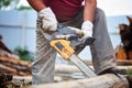 Man cut with saw. Dust and movements. Woodcutter saws tree with chainsaw on sawmill. lumberjack