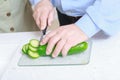 Man cuts cucumber in the kitchen Royalty Free Stock Photo