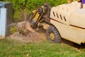 Man cuts a fallen stump grinder in action in dangerous work