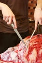 A man cuts fresh meat. Pork. Knife and fork