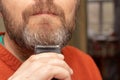 A man cuts his gray beard trimmer Royalty Free Stock Photo