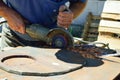 a man cuts an iron circle with a grinder