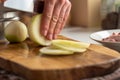 A man cuts onions on a wooden board with a sharp knife Royalty Free Stock Photo