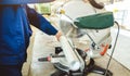 A man cuts a pipe on a circular saw. Workshop with extruders for producing plastic pipes. Royalty Free Stock Photo