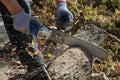 Man cuts trunk with an electric saw