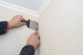 A man cuts the wallpaper with a clerical knife and a spatula. Apartment renovation, construction work Royalty Free Stock Photo