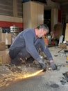 A man cutting aluminum parts in his garage to sell and support his family& x27;s food needs. The image portrays his