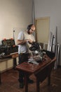 Man cutting aluminum profiles with a miter saw. Carpentry work. Construction of windows and doors for houses. Vertical image