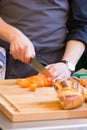 Man cutting carrots and preparing a meal on wooden chopping board Royalty Free Stock Photo