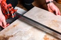 Man cutting ceramic tile with manual tile cutter. Royalty Free Stock Photo