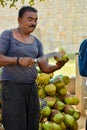 Man cutting coconut with bill hook knife in Kerala