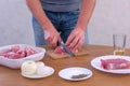 Man cutting fresh fillet meat pork on pieces to cook shashlik, hands closeup. Royalty Free Stock Photo