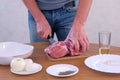 Man cutting fresh meat pork on pieces to cook shashlik, hands closeup. Royalty Free Stock Photo