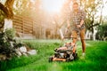 man cutting the grass in garden using lawn mower and professional gardening tools Royalty Free Stock Photo