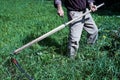 The man cutting grass with a scythe. Background, close up Royalty Free Stock Photo