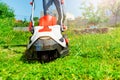 Man cutting grass using electric lawnmower in garden Royalty Free Stock Photo