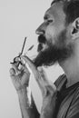 Man cutting his own beard and mustache with scissors and comb. Caucasian red bearded male trimming hair on face at home Royalty Free Stock Photo