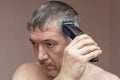 Man cutting his own hair with a clipper Royalty Free Stock Photo