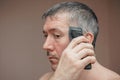 Man cutting his own hair with a clipper Royalty Free Stock Photo