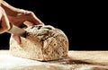 Man cutting a homemade loaf of wholegrain bread