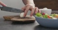 Man cutting mozzarella balls on olive wood board