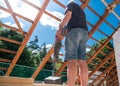 Man is cutting out the frame of a new window in the roof of a private house. A do it yourself project