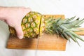 Man cutting pineapple on a wooden board Royalty Free Stock Photo