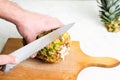 Man cutting pineapple on a wooden board Royalty Free Stock Photo